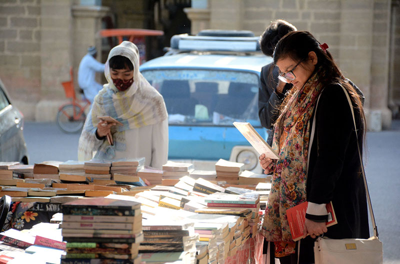 Women selecting old books at Frere Hall.
